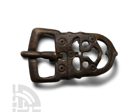 6th-8th century A.D. Comprising a D-shaped plate with openwork detailing and incised ring-and-dot motifs, rectangular loop wi