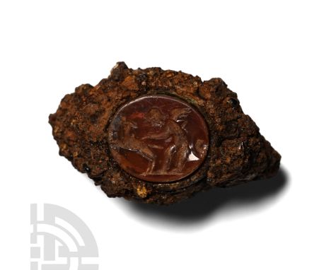2nd-3rd century A.D. Fragment of iron hoop and bezel, inset carnelian cloison with intaglio scene of a putto restraining a ba