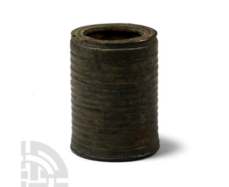 2nd-3rd century A.D. Formed as a cylinder with horizontal ribbing to the outer face, socketted mouth, applied discoid bottom 