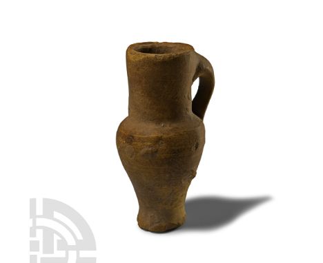 Circa 5th century B.C. Narrow in profile with tapering body and flared foot, tubular neck with strap handle to rear.  97 gram