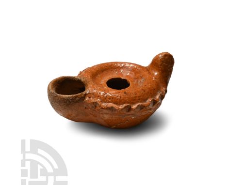 8th-10th century A.D. Squat in profile with lug handle and large D-shaped nozzle, raised discus and piecrust shoulder.  70.8 