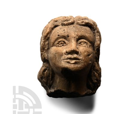 14th-16th century A.D. Modelled in the round stucco female head with centre-parted shoulder-length hair; casting flaws.  105 
