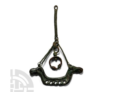 8th-10th century A.D. Twisted wire loop with swivel joint and loop, vertical twisted pendant and pierced bar with horse-head 