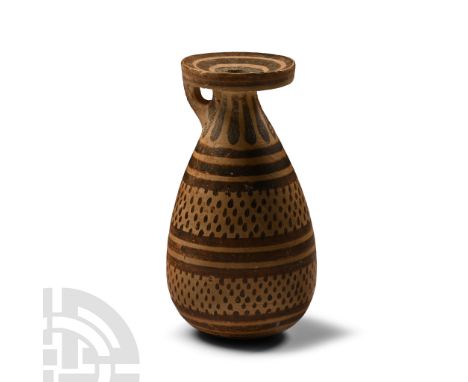 Circa 625-600 B.C. With short strap handle below mouth, piriform body, painted radiating and horizontal bands and pellets; mo