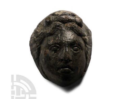 1st-2nd century A.D. Hollow-formed female face with short wavy hair framing a soft rounded face with lentoid eyes; supplied w