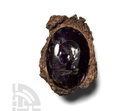 1st century A.D. Fragment of a ferrous hoop and bezel inset amethyst cabochon with intaglio profile bust of a female wearing 