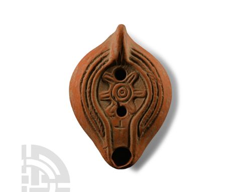 North Africa, circa 375-450 A.D. Redware oil lamp of Hayes's type I, the discus decorated with a stylised blossom, a cross be