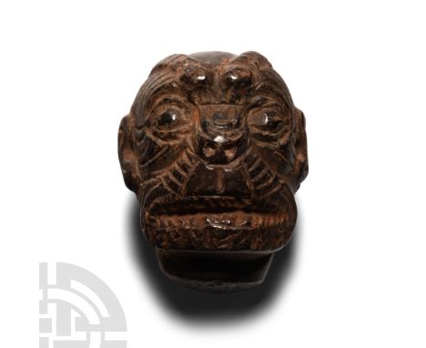 8th-7th century B.C. Modelled in the round with grotesque features and fierce teeth exposed; drilled through the head for sus
