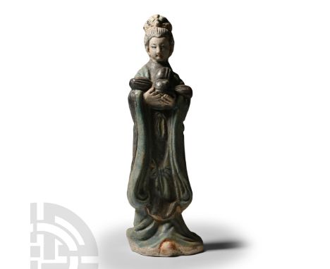20th century A.D. Hollow-formed and modelled in the round wearing long flowing robes holding a lobed helmet(?) in her cupped 
