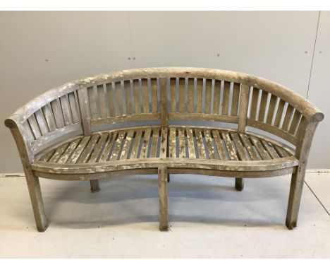 A weathered teak garden banana bench, width 150cm, depth 58cm, height 84cm. Condition -fair