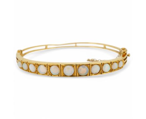 An opal bangle, the hinged bangle set to the front with cabochon opals, mounted in 9ct gold, inner circumference 17.2cm, Brit