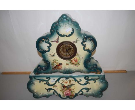 A late 19th or early 20th Century ceramic cased mantel clock and accompanying plinth