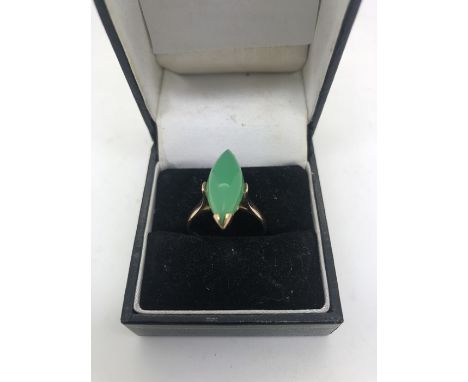 A jade dress ring set in yellow metal, marked 14ct, size O. 3.9gms total.Slight surface scratching to stone, otherwise good q