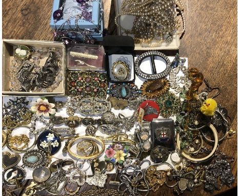 A quantity of vintage costume jewellery including brooches, chains, buckles etc with 2 leather boxes, studs etc,  