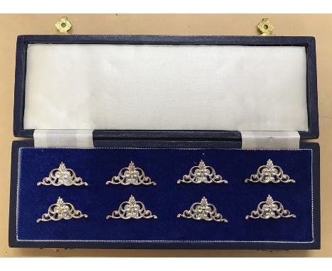 Cased set of eight hallmarked silver table place card holders AEJ Birmingham 1997. Each approx 3.5cm w x 1.5cm h and 74g.Cond