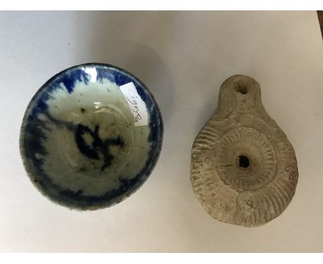Blue and white ceramic dish 6.5cm d, together with a Roman oil lamp.