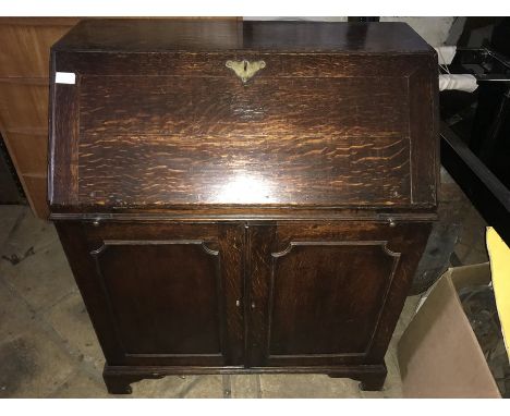 An 18thC oak bureau, fitted interior, cupboard base on bracket feet. 79 w x 43 d x 95cms h. 