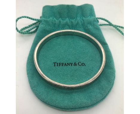 A vintage Tiffany silver bangle of typical round form with engraved T &amp; Co, the interior marked 1997 Tiffany and Co .925.