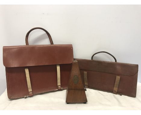 A Maelzel metronome with two leather music cases.