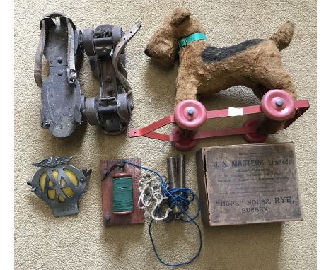 Pull along soft toy terrier dog, roller skates, electric shock machine and a AA grill badge. 