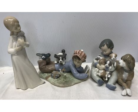 A group of three Lladro figurines, baby boy with dog and puppies 13cm, boy reading with dog and small bird 10cm, and a young 