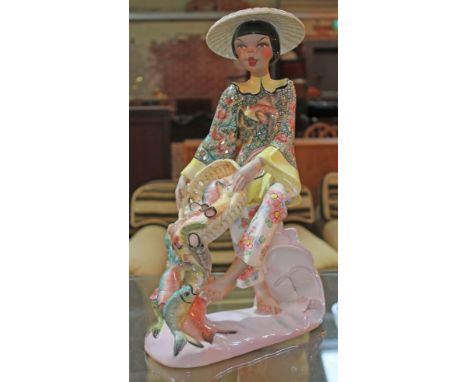 A vintage Italian pottery figure depicting a girl holding a basket of fish by Tiziano Galli circa 1960s.  Condition - good, n
