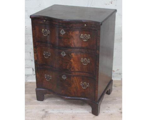 An early 20th century reproduction George II style serpentine chest of drawers of small proportions with brushing slide, bras