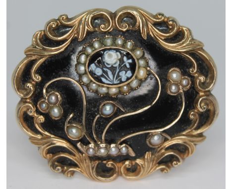 A 19th century yellow metal mourning brooch, having applied thistle and flower cameo within a baroque pearl and scroll work f