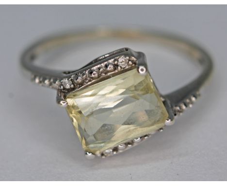 A 10ct white gold ring set with a pale yellow mixed cut stone, marked '10k', gross wt. 1.81g, size J.  