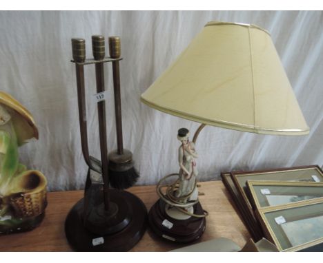 A copper and brass companion stand on wooden base with a modern figurine table lamp