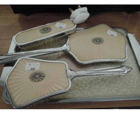 A vintage dressing table set with pale salmon guilloche design