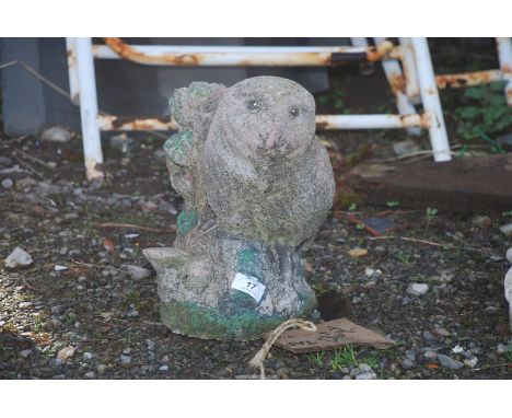 Concrete figure of Owl on a tree trunk.