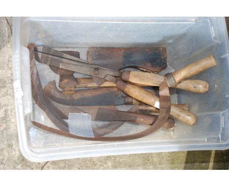 Tub of hedge bills, axe head, hackers, etc.