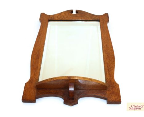 An Art Deco golden oak bevel edged wall mirror with integral shelf, 63cm x 41cm 