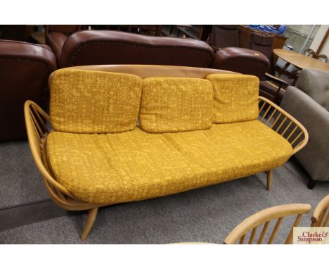 A light Ercol stick back three seater settee