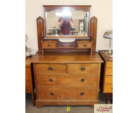 An early 20th Century oak dressing chest, having raised mirrored back, fitted two trinket drawers, two short and two long dra