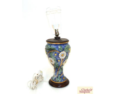 A continental pottery baluster table lamp, having foliate decoration and white shade, 69cm high 