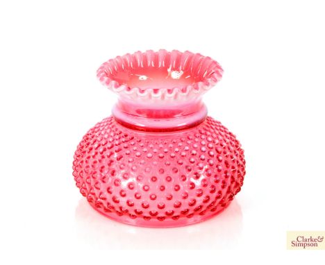 A cranberry glass oil lamp shade having raised point decoration and frilled rim, 16.5cm high 