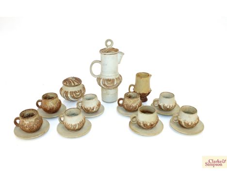 A Bernard Rooke pottery coffee set, having raised floral decoration comprising eight coffee cups and saucers, a covered sucri