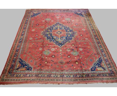 USHAK CARPET, West/Central Anatolia, circa 1920, the pale maroon field centred by a stepped indigo medallion framed by spandr