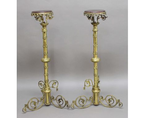 PAIR OF BRASS TELESCOPIC TORCHERES, the wooden trays on scrolling mounts, the columns applied with a knop and bees, on a scro