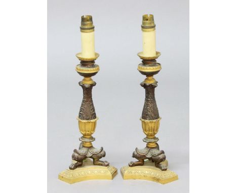 PAIR OF EMPIRE STYLE LAMP BASES, the gilt sconces above bronzed foliate stems of waisted form, on lion's paw feet and tripod 