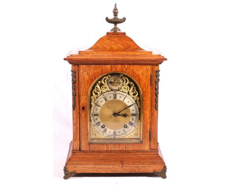 Winterholder and Hoffmeier oak mantle clock, the arched brass Roman dial with slow / fast regulator chiming on a gong