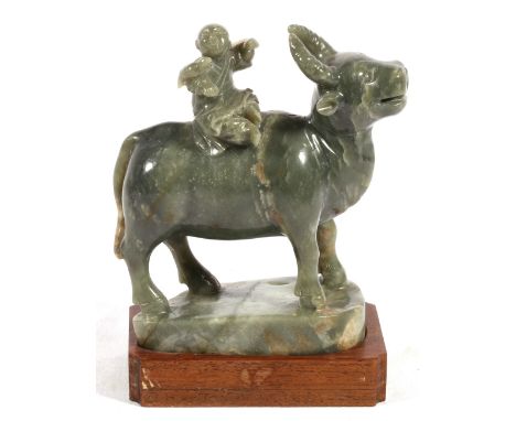 Chinese early 20th century grey green and mottled brown jade carving of a boy seated on a buffalo, a bird resting on his arm,