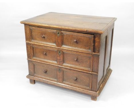 A 17thC and later oak chest, of three deep drawers with twin panel fronts and pierced brass key escutcheons, on stile legs an