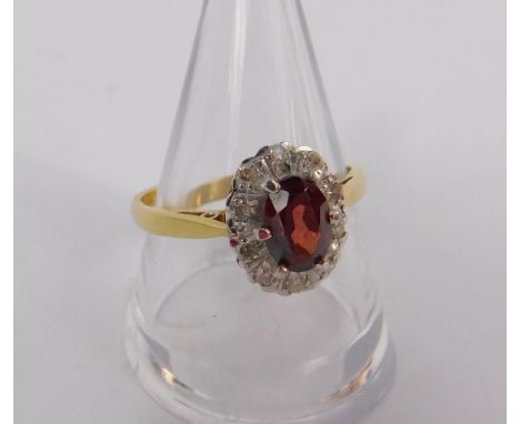 An 18ct gold red stone and diamond set ring, possibly a spinel, in an opal design, size Q, 4.0g.