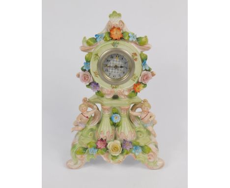 A Continental early 20thC porcelain mantel clock, white metal dial bearing Arabic numerals, the green rococo case, mounted wi