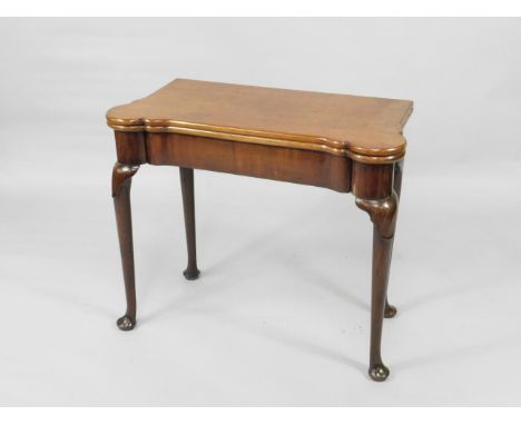 A George II mahogany turnover top card table, with green beize lining and counter cups and candle stands to the playing surfa