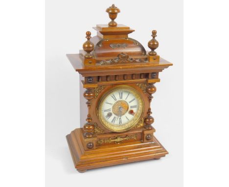 A Hamburg American Clock Co late 19thC walnut cased mantel clock, circular brass dial with enamel chapter ring bearing Roman 