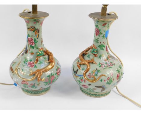A pair of 19thC Chinese celadon and famille rose vases, the circular body raised with a decorative gilt highlighted dragon an